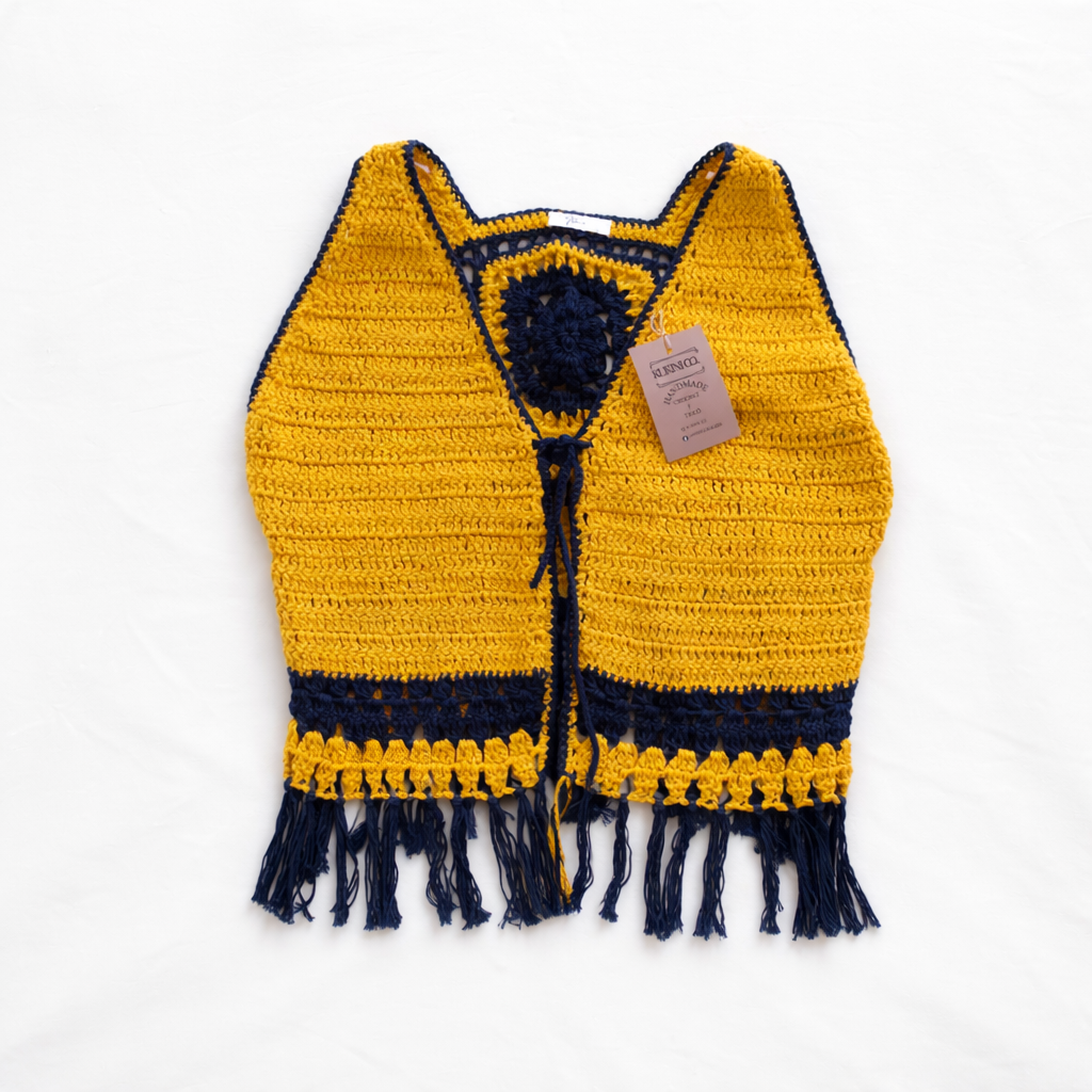 Colete de crochê amarelo da Kukini Co. com detalhes artesanais, mostrado em uma imagem com fundo neutro.