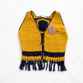 Colete de crochê amarelo da Kukini Co. com detalhes artesanais, mostrado em uma imagem com fundo neutro.