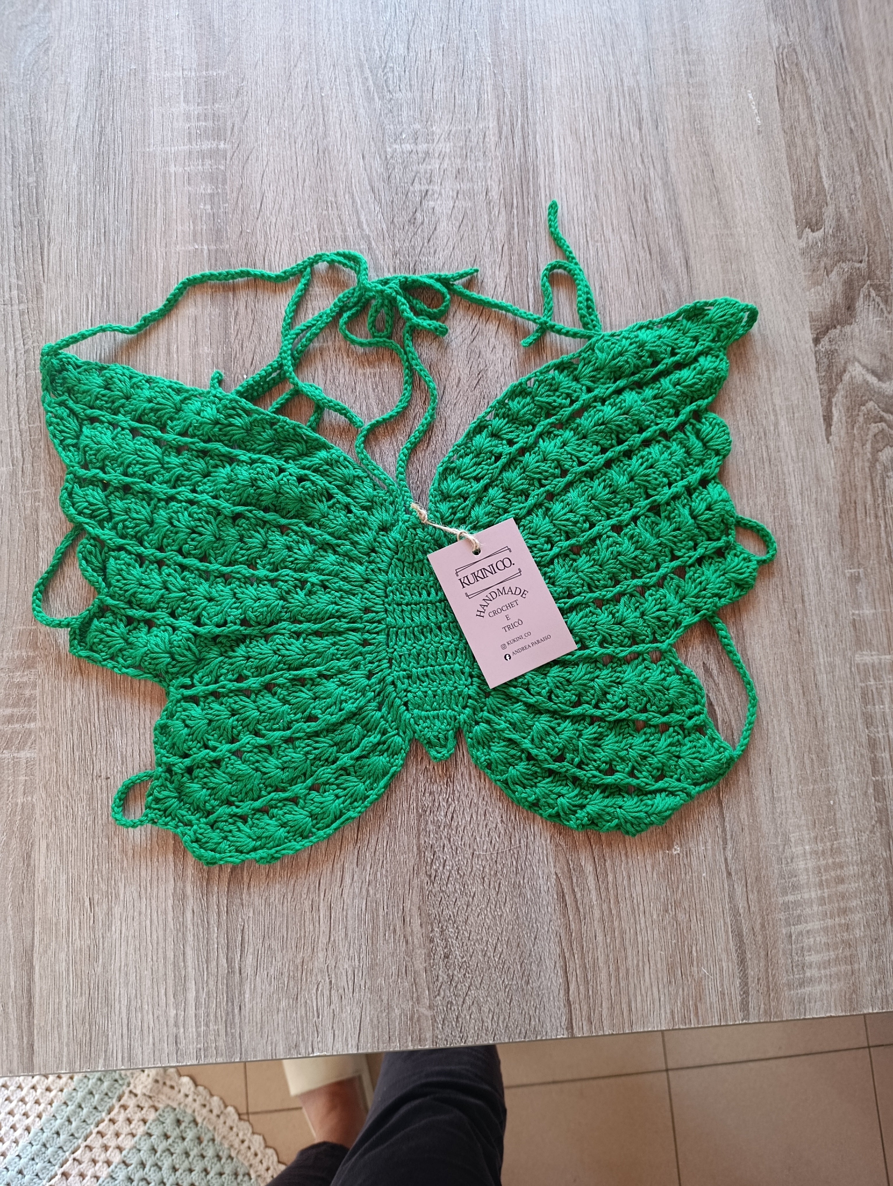 Top de crochê com detalhe de borboleta verde da Kukini Co., tecido leve e delicado, aparência artesanal e elegante.
