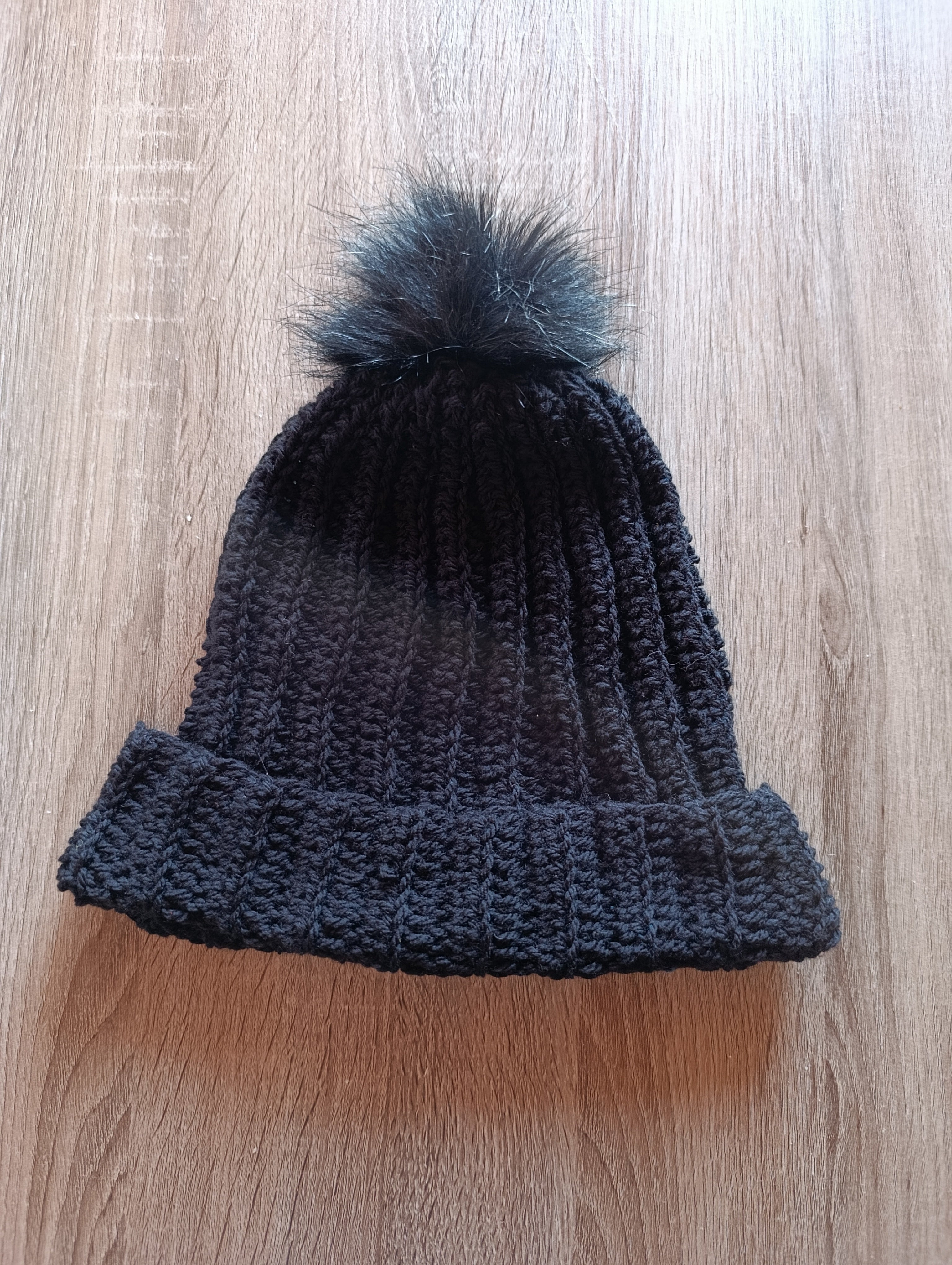Gorro de crochê preto com pompom da Kukini Co., detalhe do tecido de crochê e pompom decorativo na parte superior.