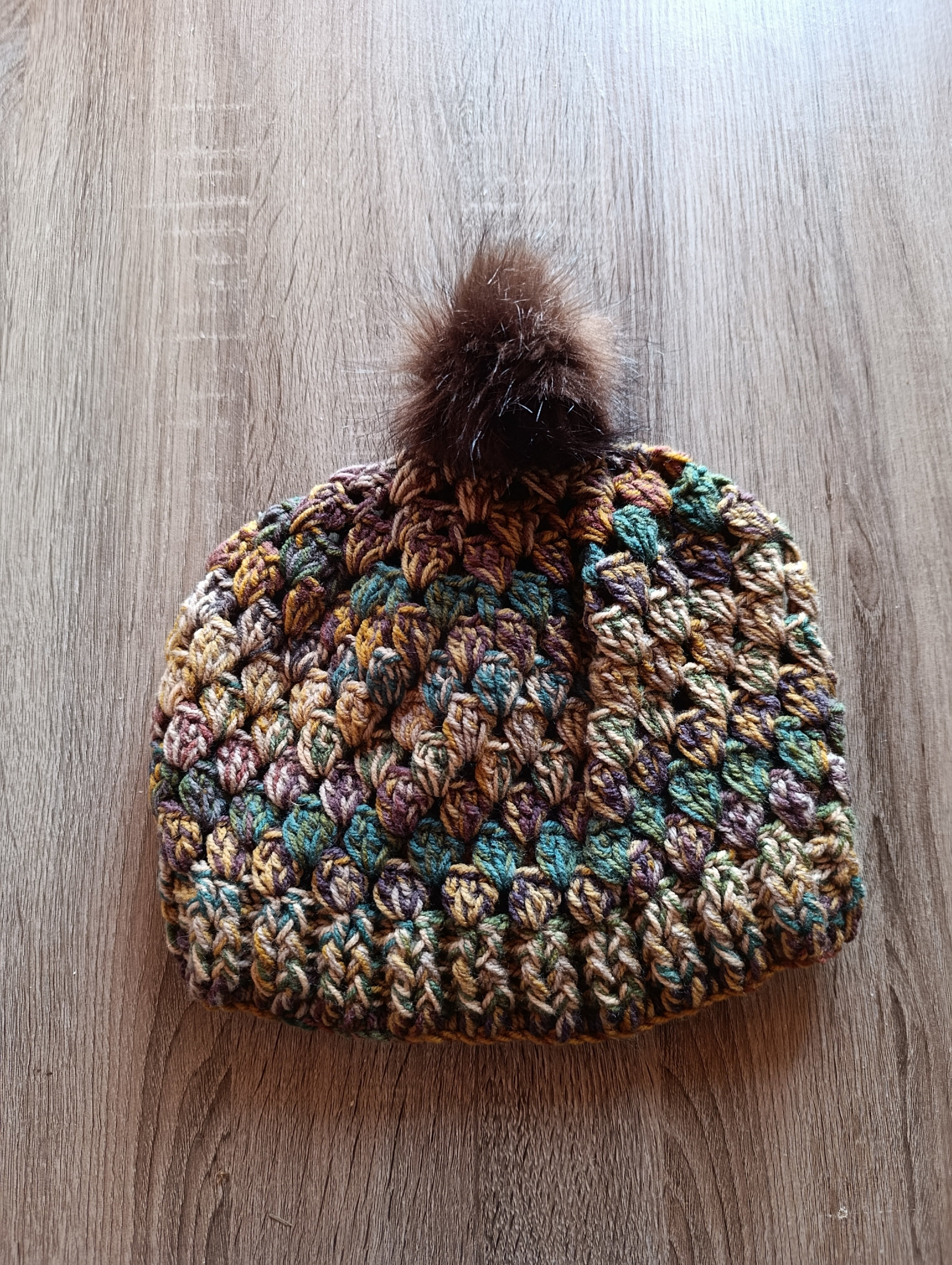 Gorro de crochê Granny Square multicolor com pompom, feito à mão pela Kukini Co., mostrando detalhes coloridos e texturizados.