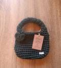 Mini tote bag de crochê verde escuro da Kukini Co. com alça e detalhes visíveis na imagem.