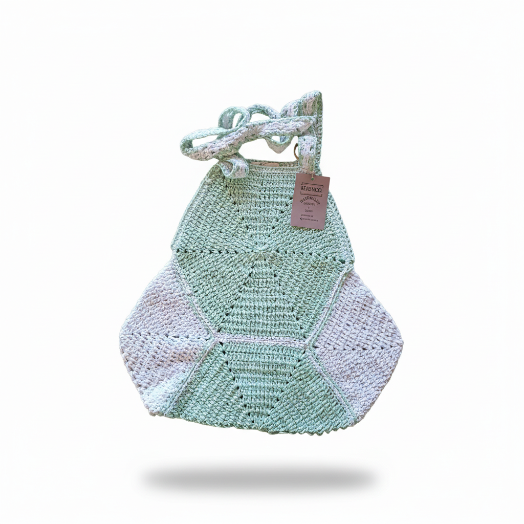 Mochila de crochê hexagonal para praia na cor verde mint, feita pela Kukini Co., com detalhes artesanais visíveis.