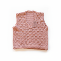 Colete de crochê rosa salmão da Kukini Co., detalhe de ponto de crochê, modelo feminino com acabamento delicado.