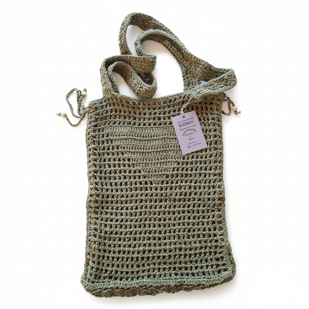 Mala de crochet filet de praia Kukini Co. em tom verde khaki, com detalhes em crochê e alça resistente.