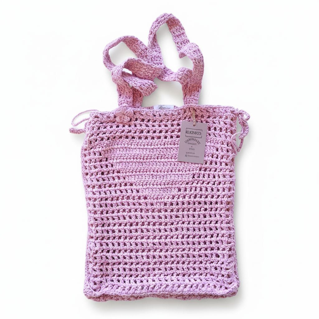 Mala de crochet para praia rosa da Kukini Co., com acabamento em filet e alça de mão.