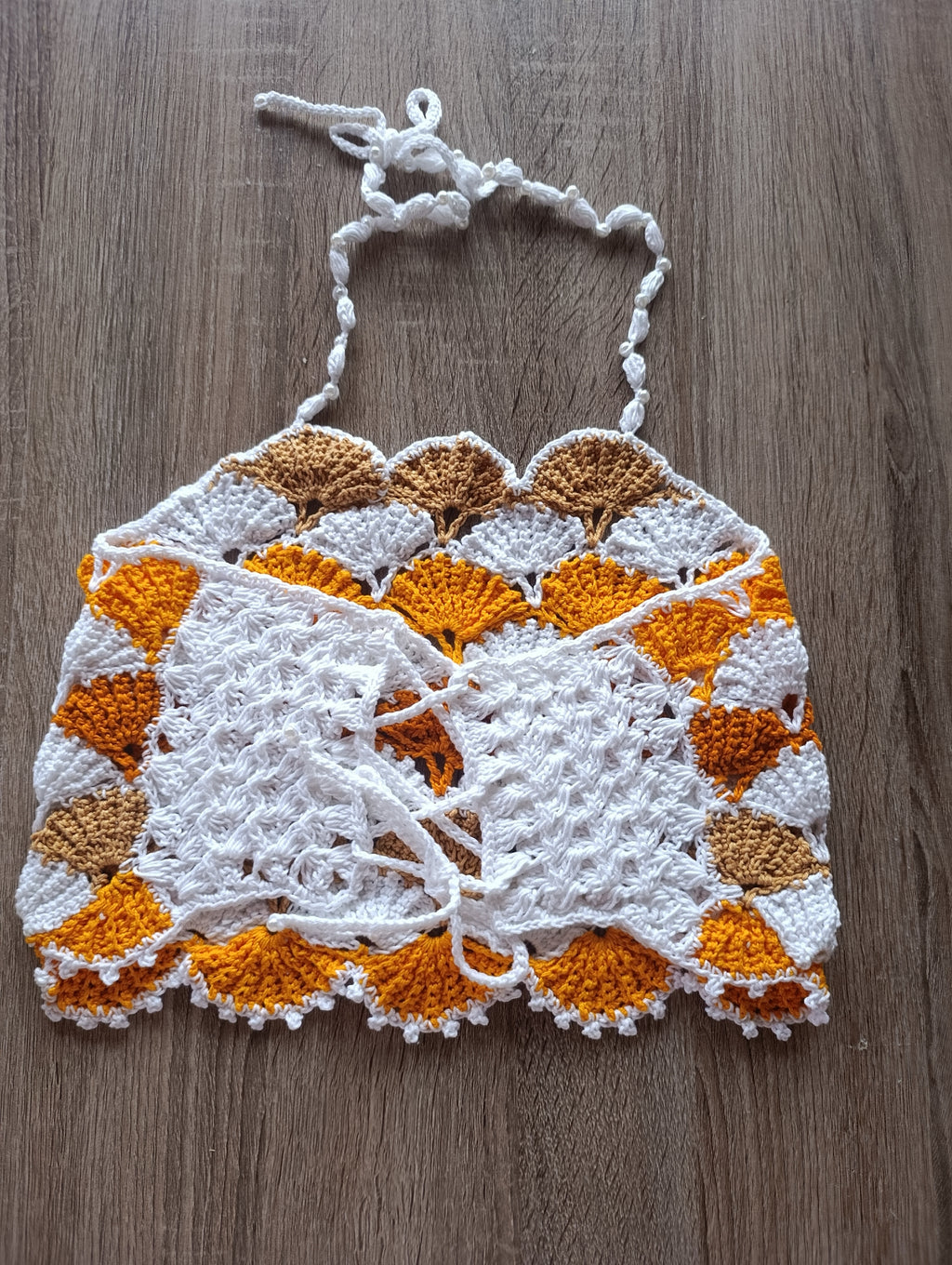 Top de crochê com pérolas feito à mão, da marca Kukini Co., exibindo detalhes de acabamento e acabamento delicado.