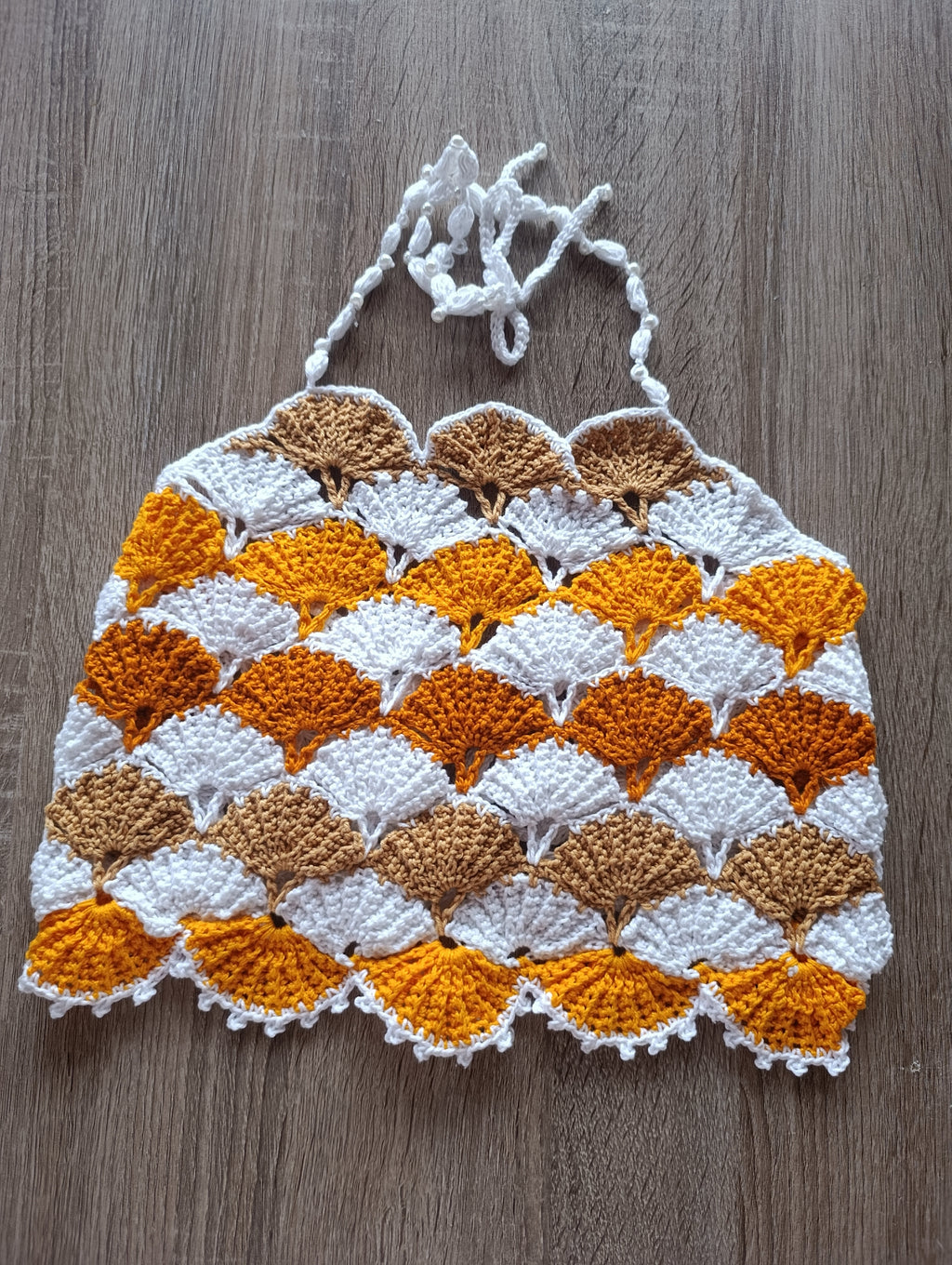 Top de crochê com pérolas feito à mão da Kukini co., mostrando detalhes do tecido e adornos de pérolas brancas.